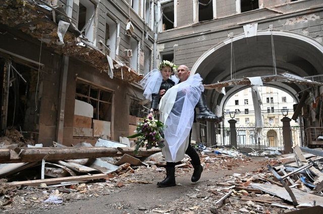 Ukrainë, të sapomartuarit bëjnë foto në rrënojat e pallatit të bombarduar